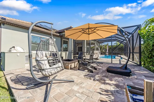 a view of a patio with a table and chairs under an umbrella