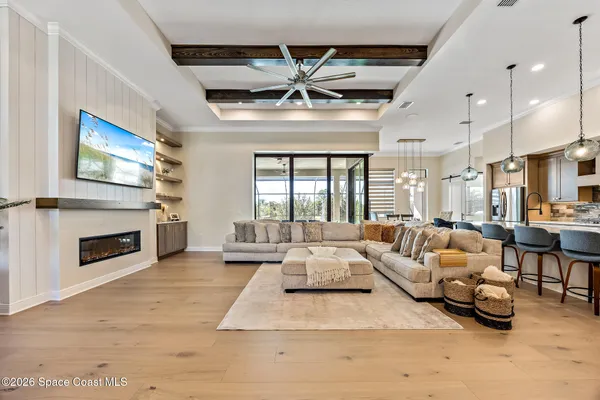 a outdoor living space with furniture a fireplace and a ceiling fan