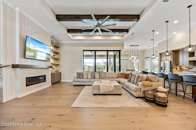 a outdoor living space with furniture a fireplace and a ceiling fan