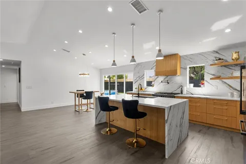 a kitchen with a table chairs stove and cabinets