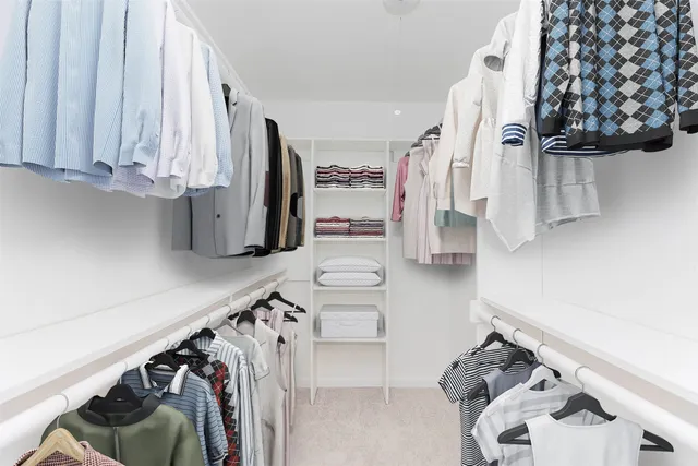 a view of walk in closet with clothes and shoes