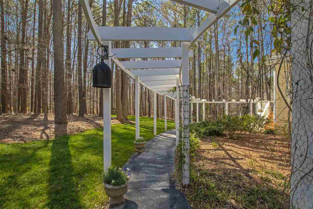 5817 Laurel Rock Lane Raleigh, NC 27613 - Photo 28 of 30 Stroll down the walkway through the pergola and out to the yard! The rear of the lot is still heavily wooded providing excellent privacy. Beautifully landscaped with in-ground irrigation system and underground electric dog fence! Pergola and Walkway