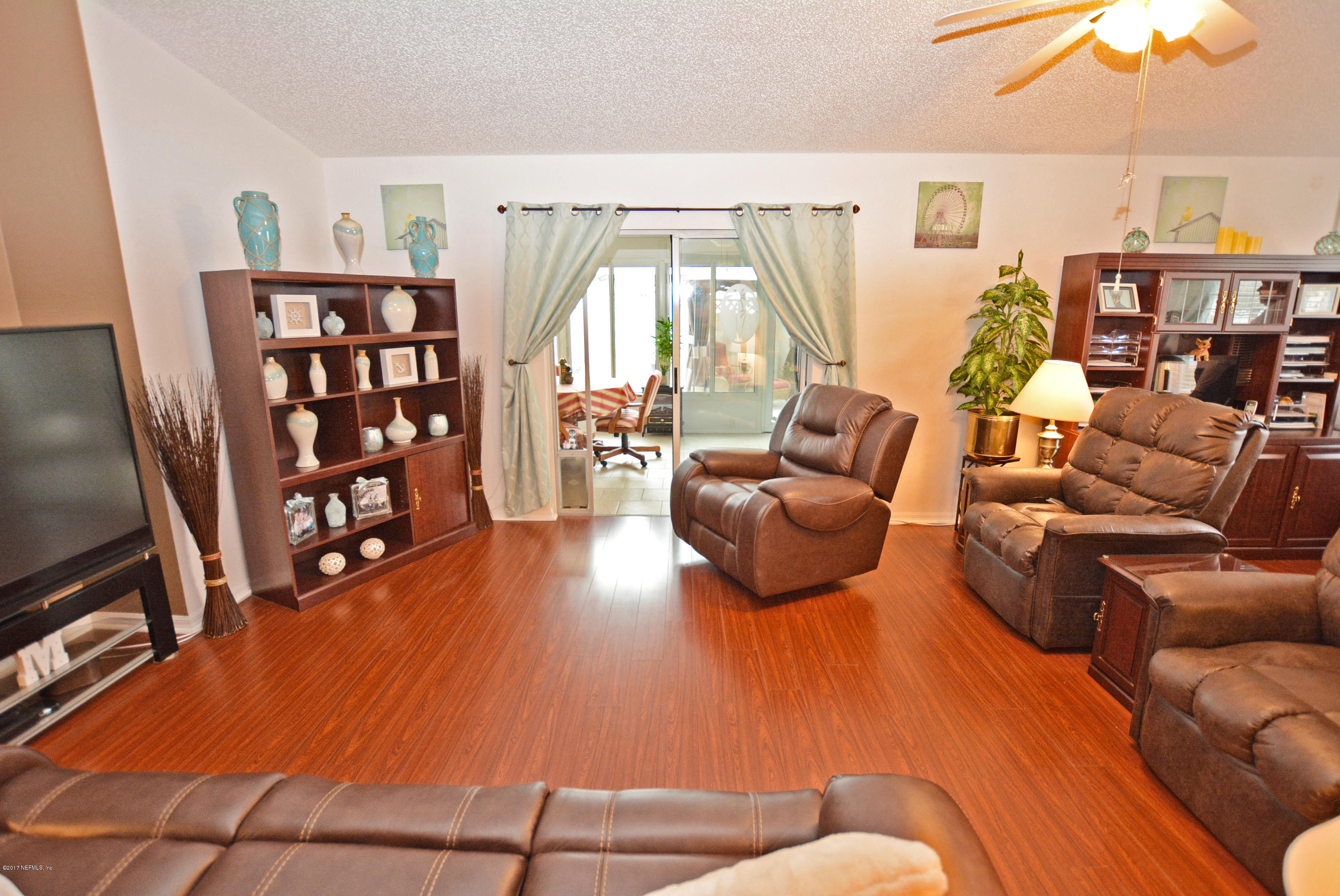 7319 Gum Tree Road Jacksonville, FL 32244 - Photo 14 of 41 a living room with furniture a flat screen tv and a large window
