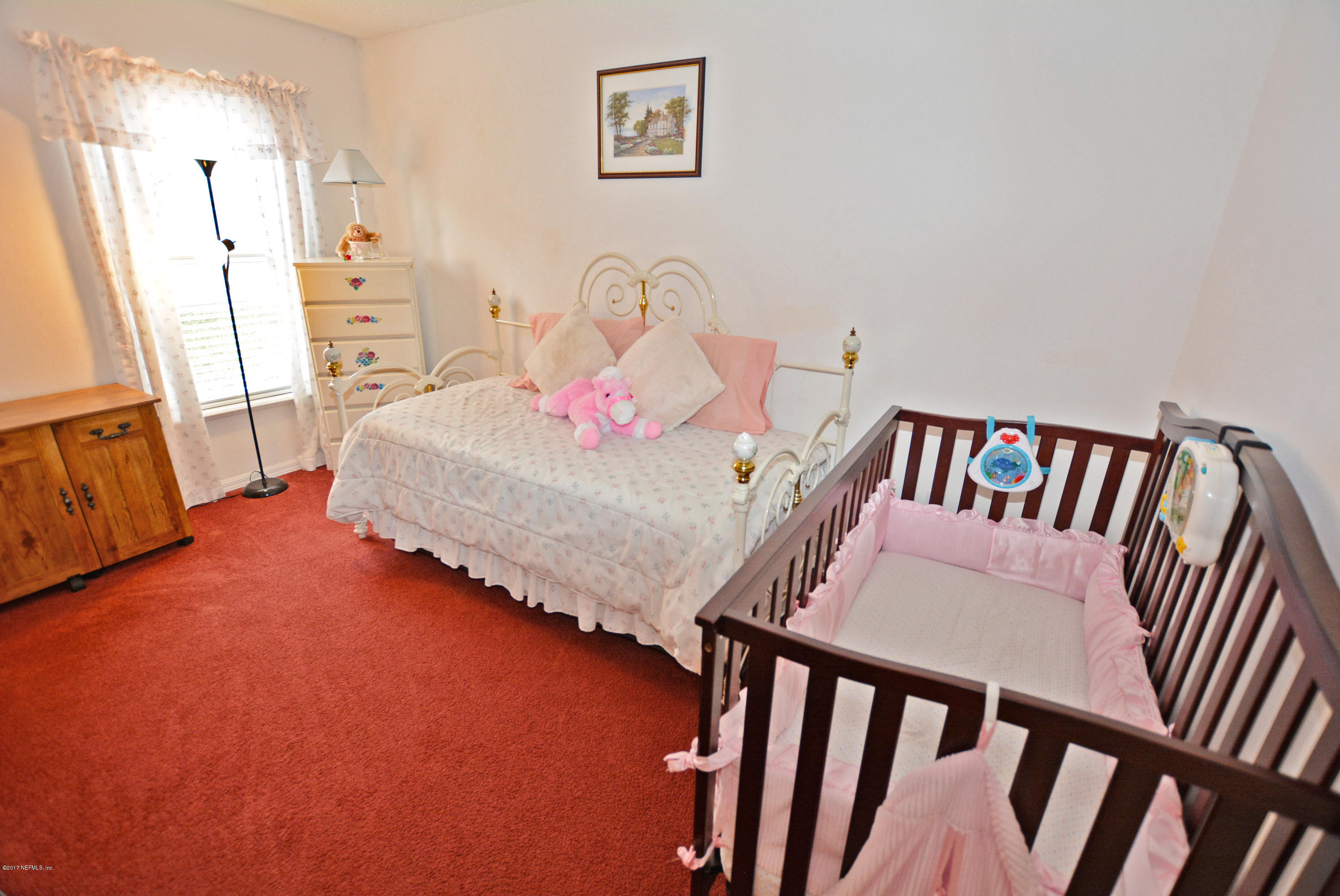 7319 Gum Tree Road Jacksonville, FL 32244 - Photo 29 of 41 a bedroom with furniture and a wooden floor
