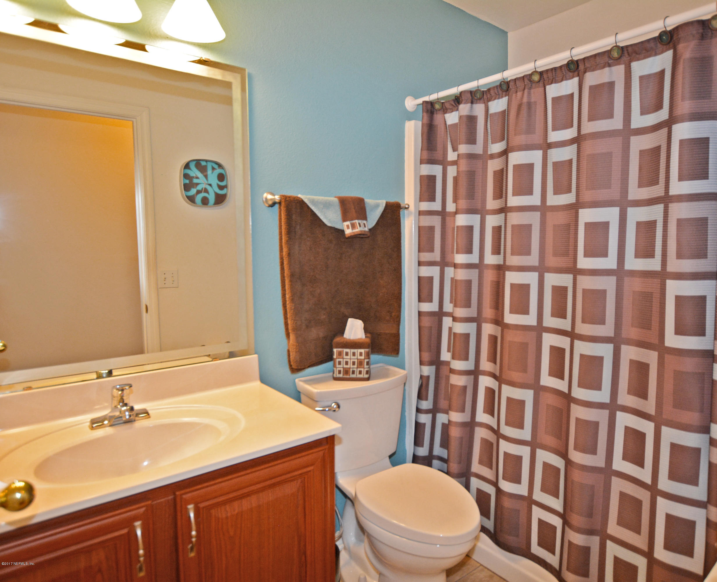 7319 Gum Tree Road Jacksonville, FL 32244 - Photo 31 of 41 a bathroom with a sink a toilet and shower curtain
