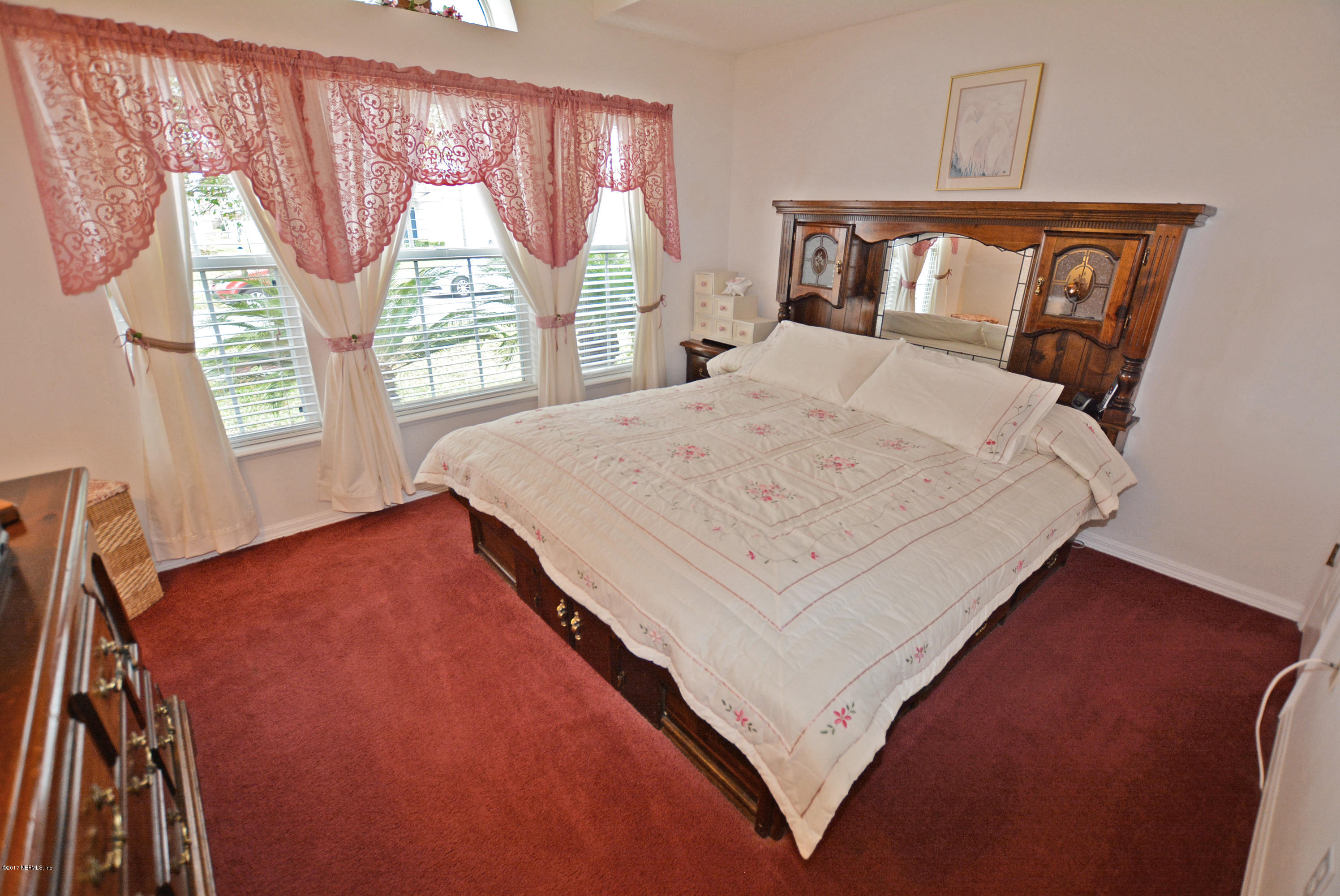 7319 Gum Tree Road Jacksonville, FL 32244 - Photo 32 of 41 a bed sitting in a bedroom next to a window