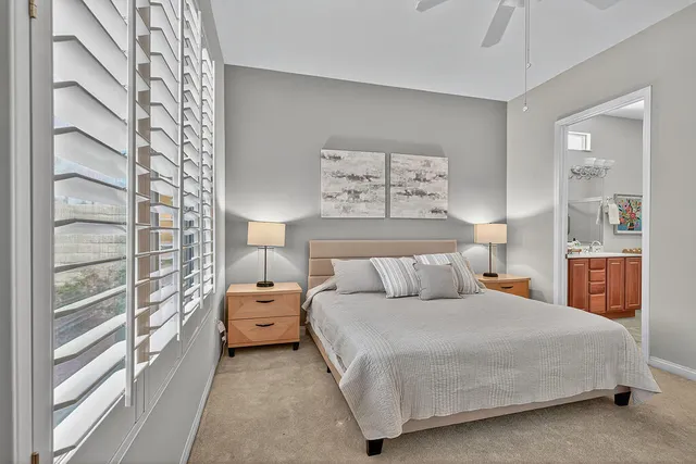 a bedroom with a bed and a lamp on dresser