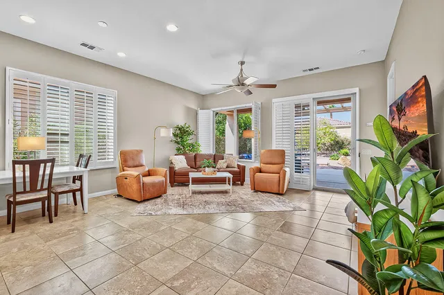 a living room with furniture a large window and a flat screen tv