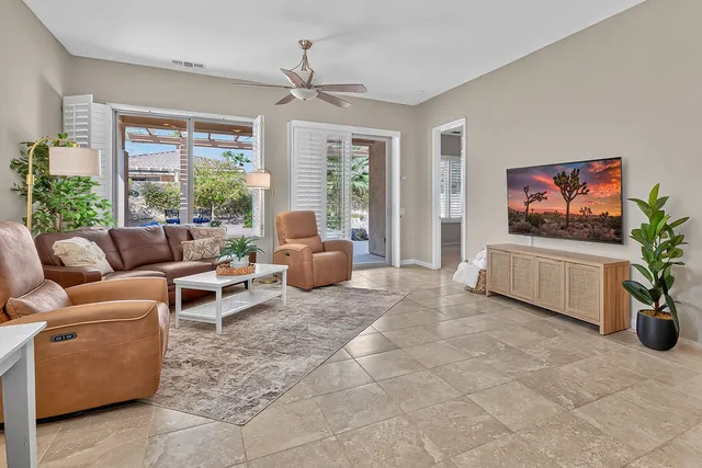 a living room with furniture a window and a flat screen tv