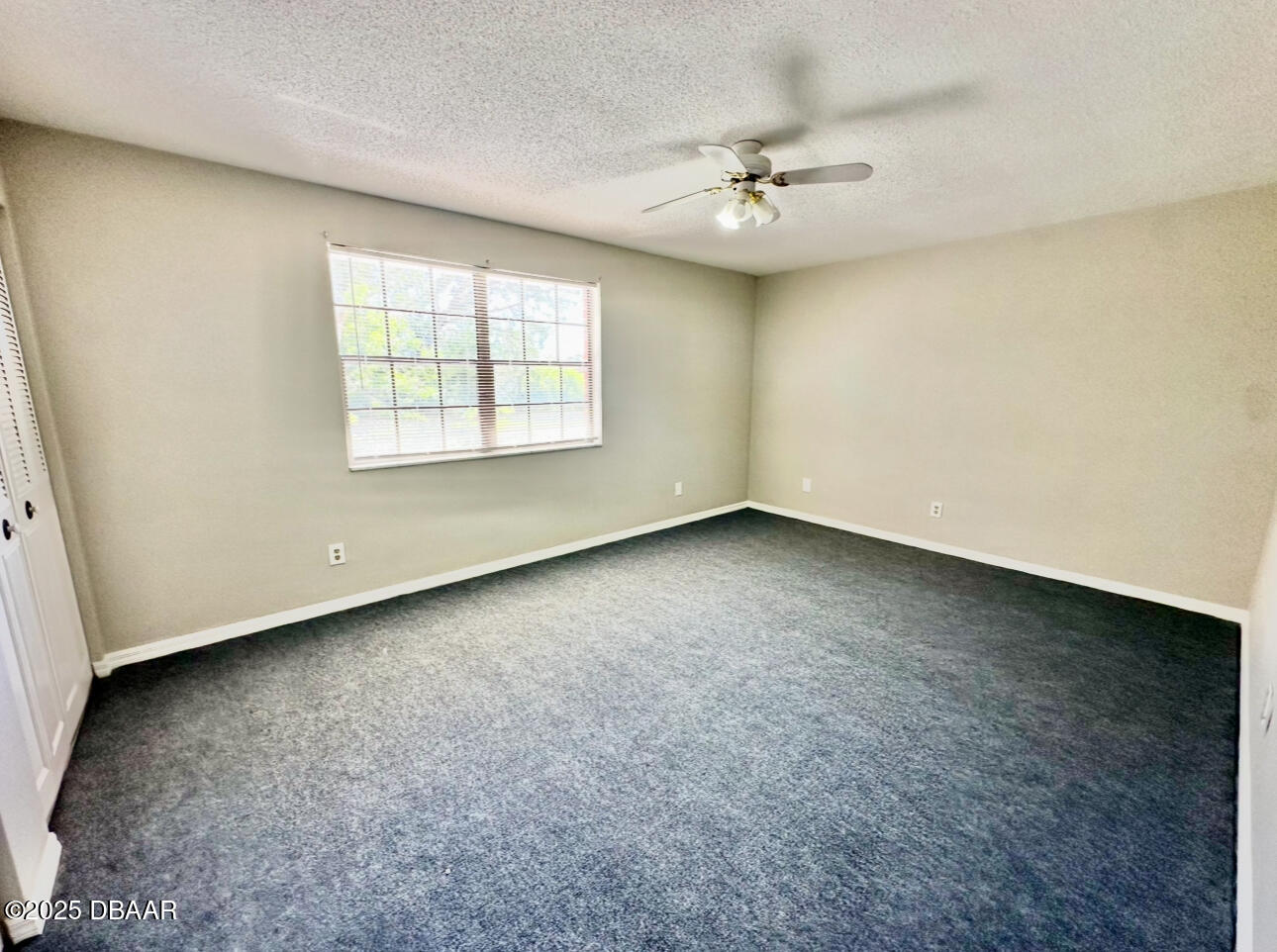 2250 South Palmetto Avenue, Unit J3 South Daytona, FL 32119 - Photo 11 of 20 an empty room with a ceiling fan and window