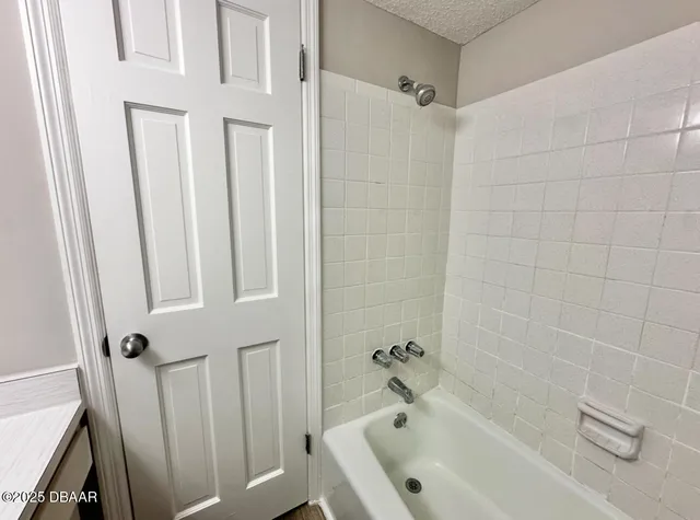 a bathroom with a tub a sink a window and a shower