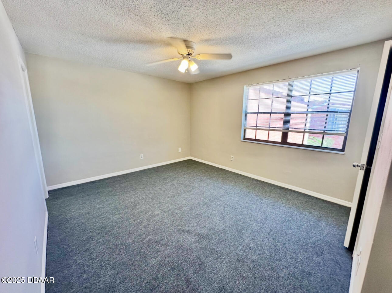 2250 South Palmetto Avenue, Unit J3 South Daytona, FL 32119 - Photo 16 of 20 an empty room with windows and chandelier fan