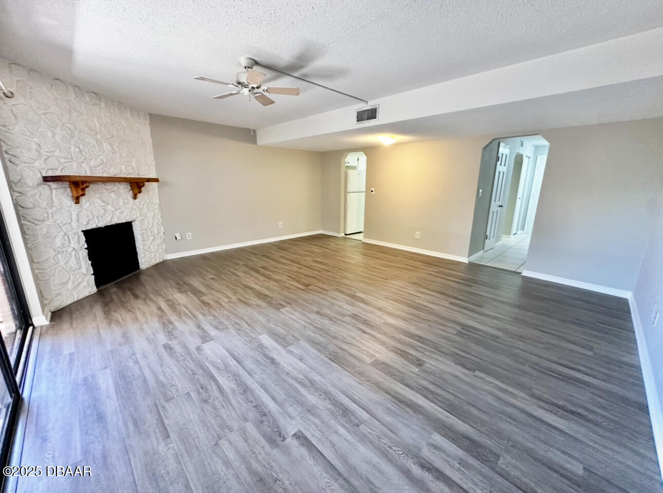 2250 South Palmetto Avenue, Unit J3 South Daytona, FL 32119 - Photo 3 of 20 an empty room with wooden floor fireplace and windows