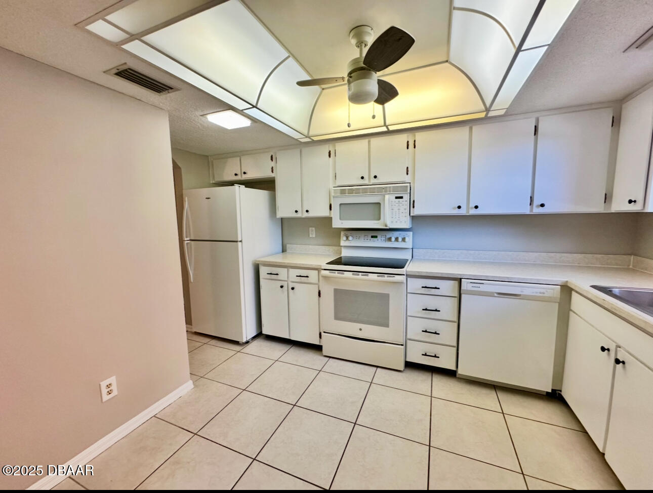2250 South Palmetto Avenue, Unit J3 South Daytona, FL 32119 - Photo 6 of 20 a kitchen with white cabinets appliances and a sink