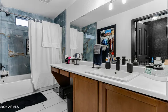 a bathroom with double vanity sinks a bathtub and a mirror