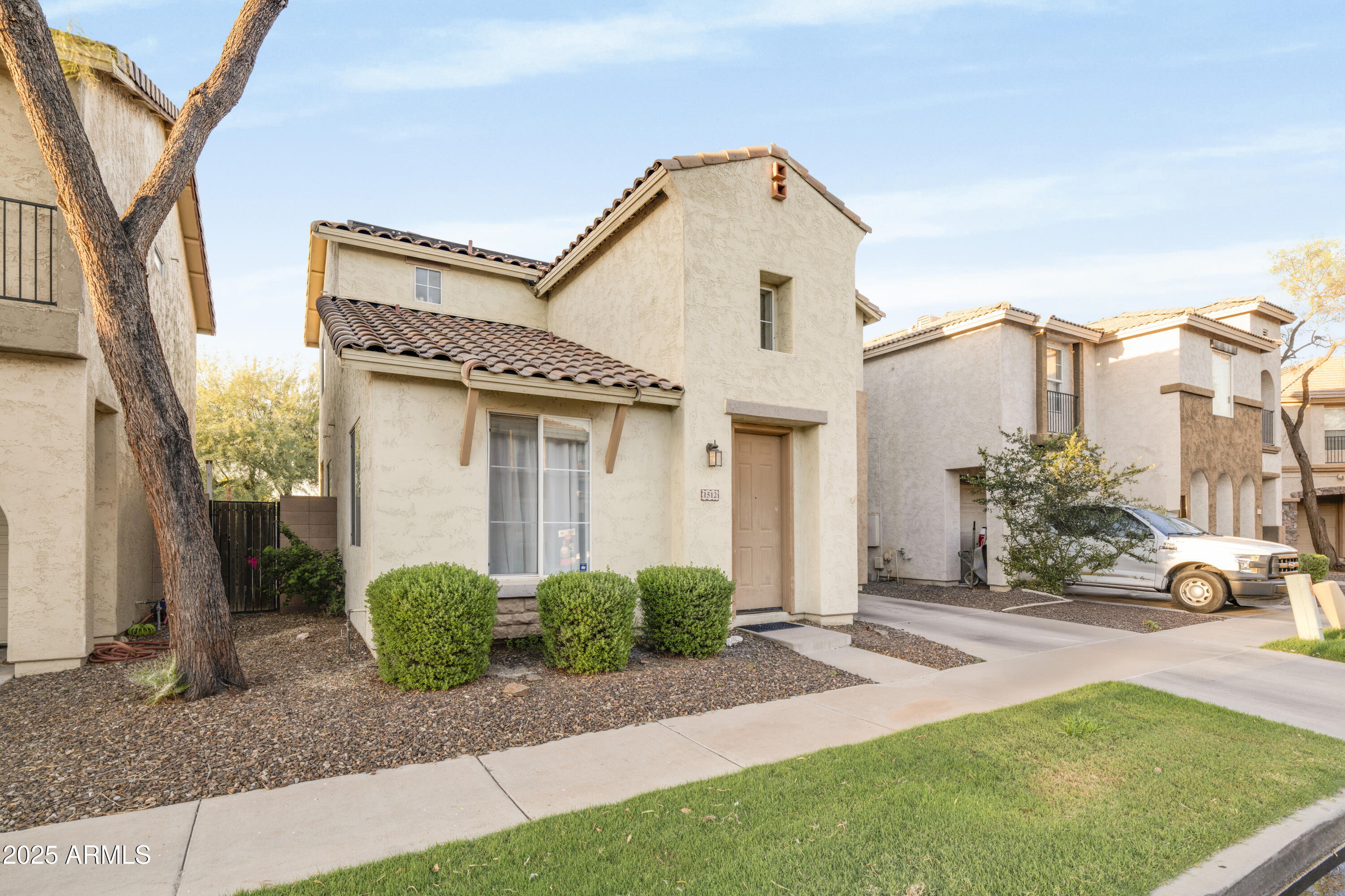 1512 East Chipman Road Phoenix, AZ 85040 - Photo 2 of 21 a view of a white house with a small yard and large tree and plants