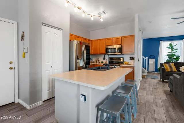 a large kitchen with sink a refrigerator and chairs