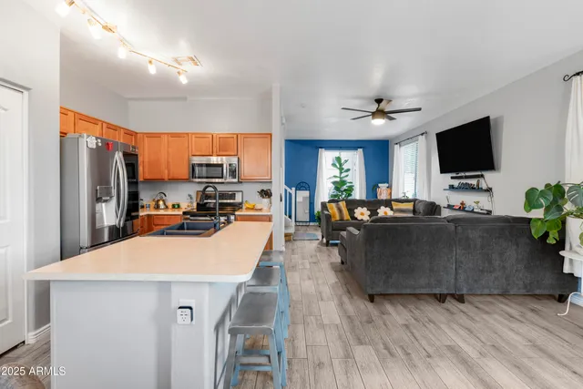 a living room with furniture a flat screen tv and kitchen view