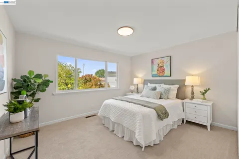 a bedroom with a bed and painting on the wall