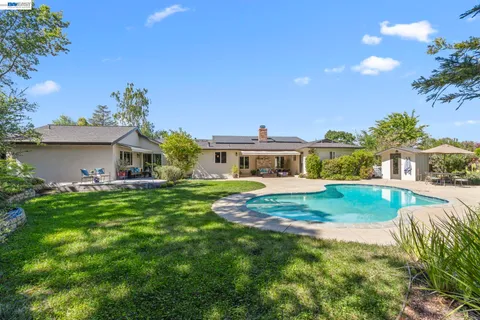 a view of yard with swimming pool and green space