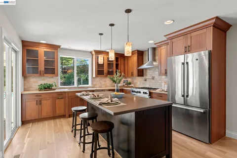 a kitchen with sink a refrigerator and chairs