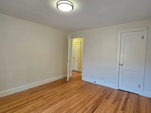 an empty room with wooden floor and closet