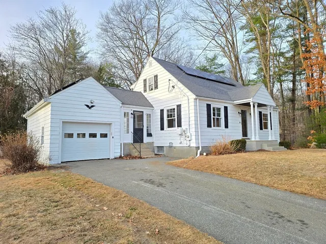 a front view of a house with a yard and trees