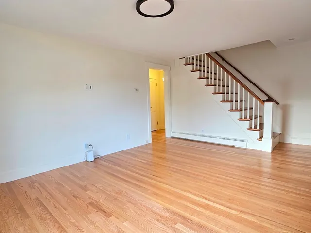 a view of a room with wooden floor and white walls