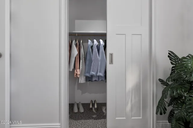 a view of walk in closet with clothes and shoes