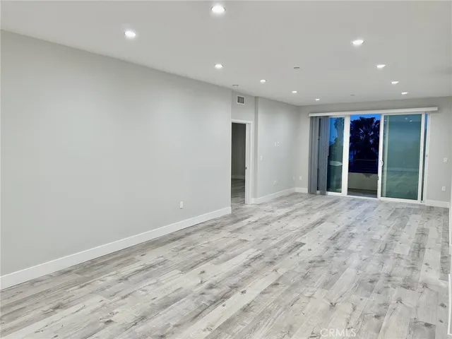 an empty room with wooden floor and window