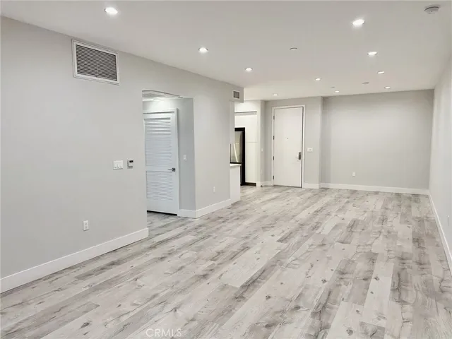 an empty room with wooden floor and mirror