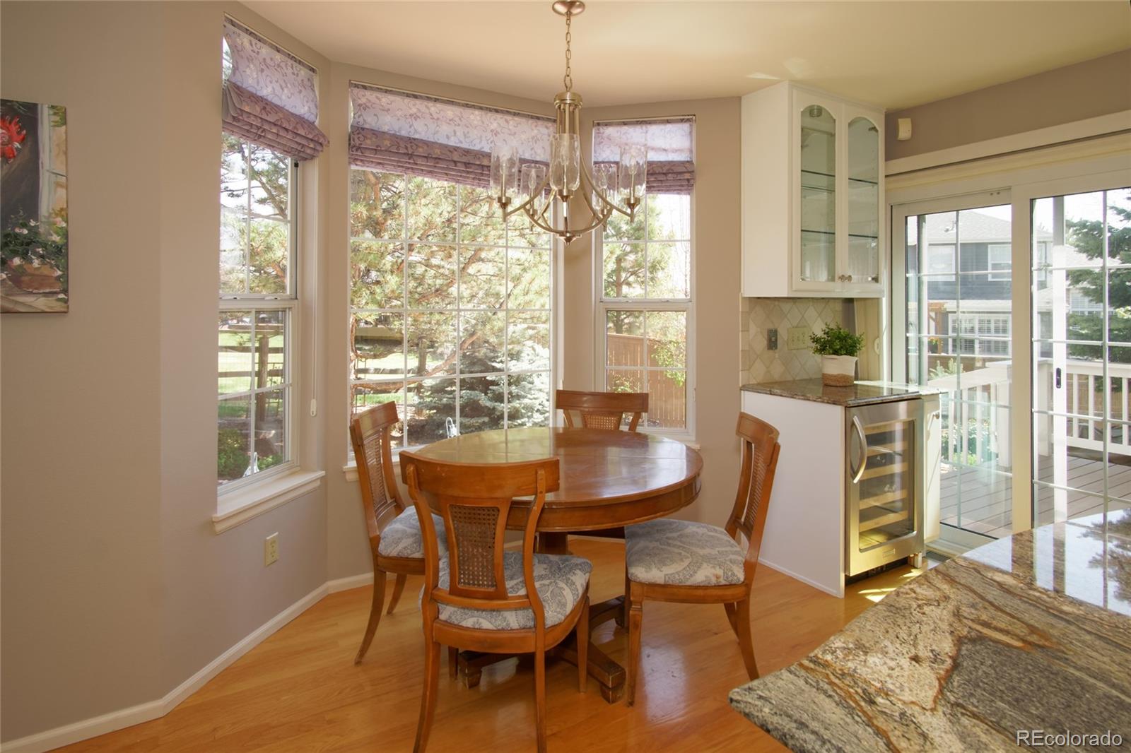 8592 Forrest Street Highlands Ranch, CO 80126 - Photo 13 of 40 a dining room with furniture a chandelier and wooden floor