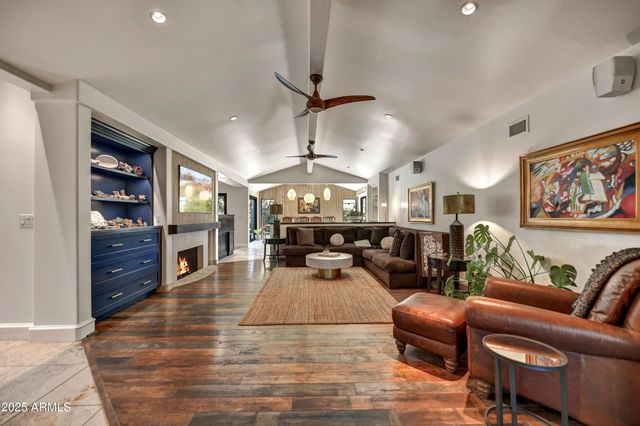 a living room with furniture a fireplace and a floor to ceiling window