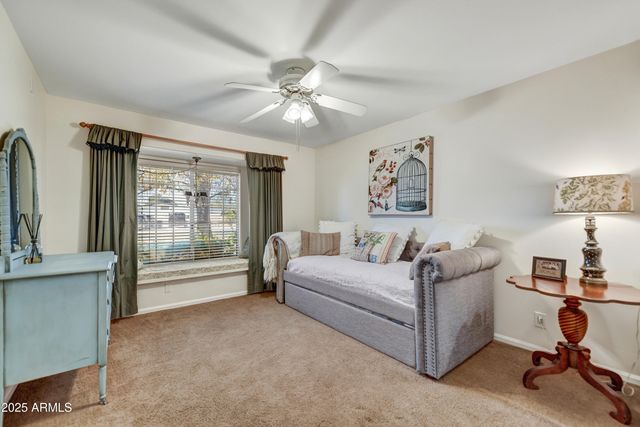 a bedroom with bed a flat tv screen and a dresser