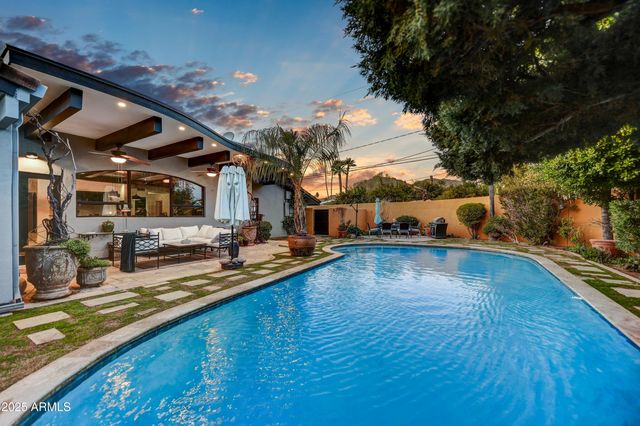 an aerial view of a house with swimming pool and patio