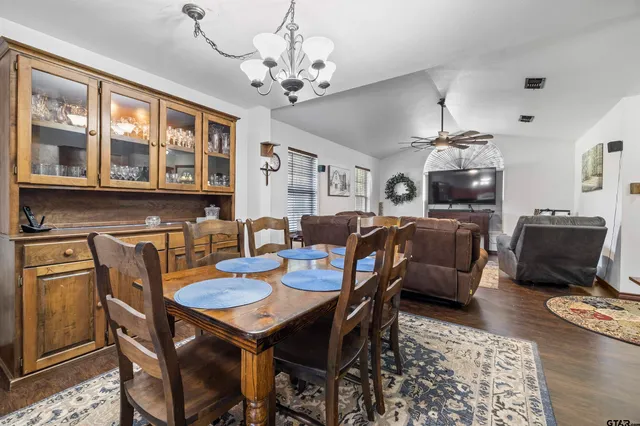 a view of a dining room with furniture a chandelier and wooden floor