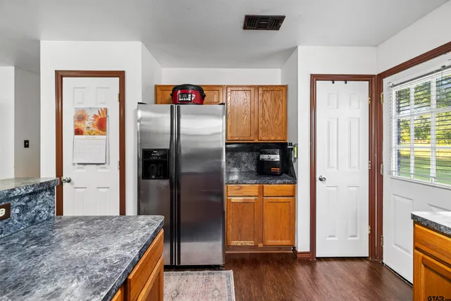 a kitchen with stainless steel appliances granite countertop a refrigerator and a sink