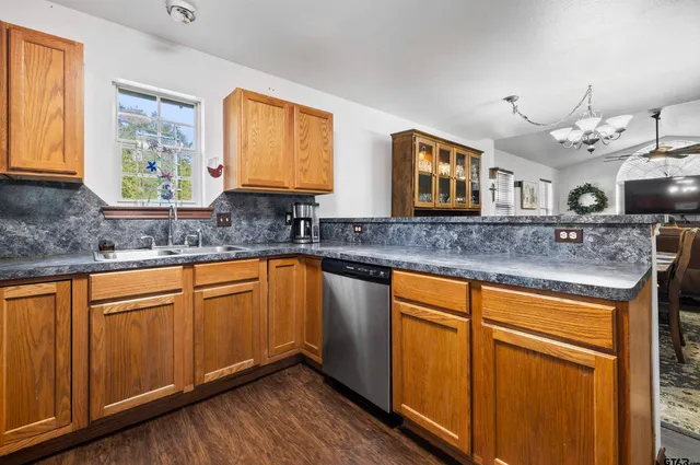 a kitchen with stainless steel appliances granite countertop wooden cabinets a sink and a granite counter tops