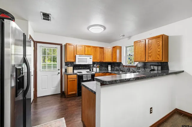 a kitchen with stainless steel appliances granite countertop a sink stove and refrigerator