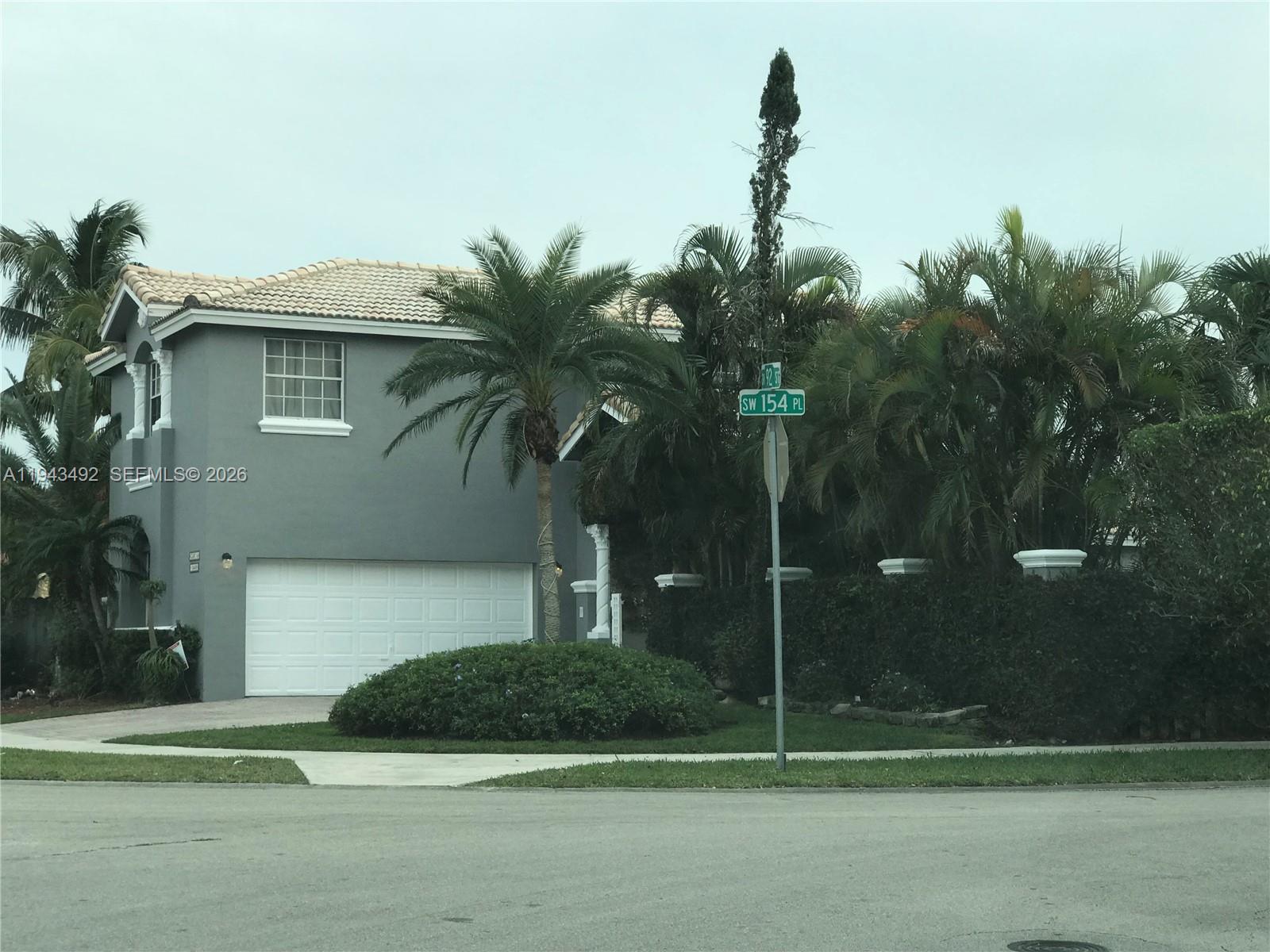 15448 Southwest 92nd Street Miami, FL 33196 - Photo 12 of 36 a front view of a house with a yard