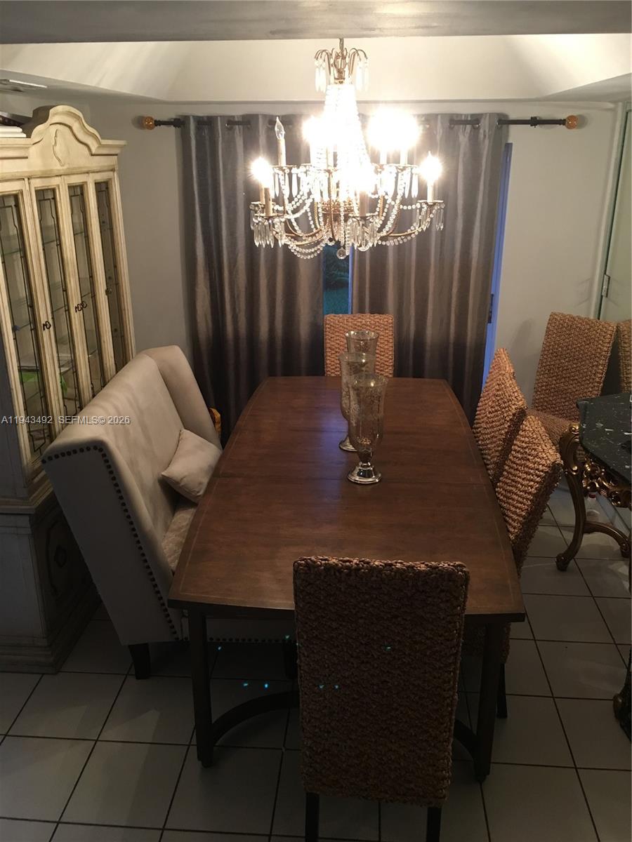 15448 Southwest 92nd Street Miami, FL 33196 - Photo 14 of 36 a view of a dining room with furniture and chandelier