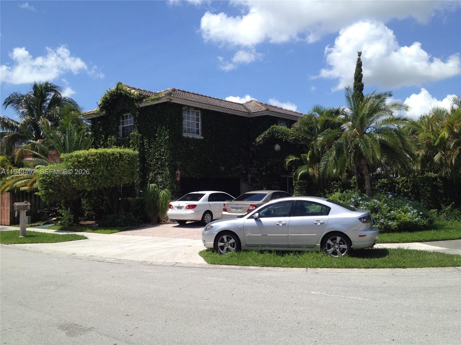 15448 Southwest 92nd Street Miami, FL 33196 - Photo 19 of 36 a view of a car parked in front of a house with a yard