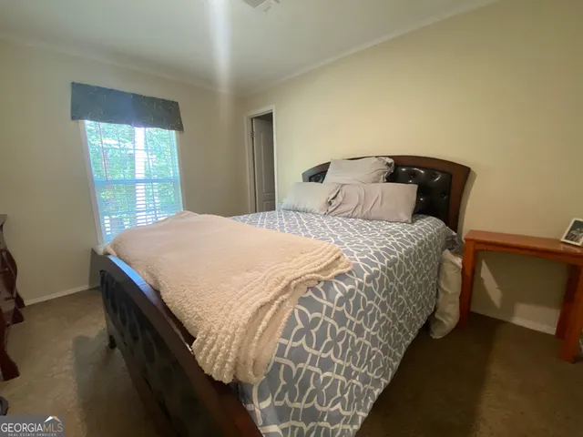 a bedroom with a bed chair and a window