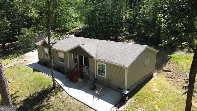 a view of a yard with plants and large trees