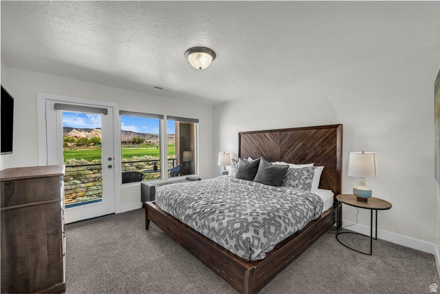 5010 Escapes Drive St. George, UT 84770 - Photo 18 of 46 Bedroom with a textured ceiling, access to exterior, and dark carpet
