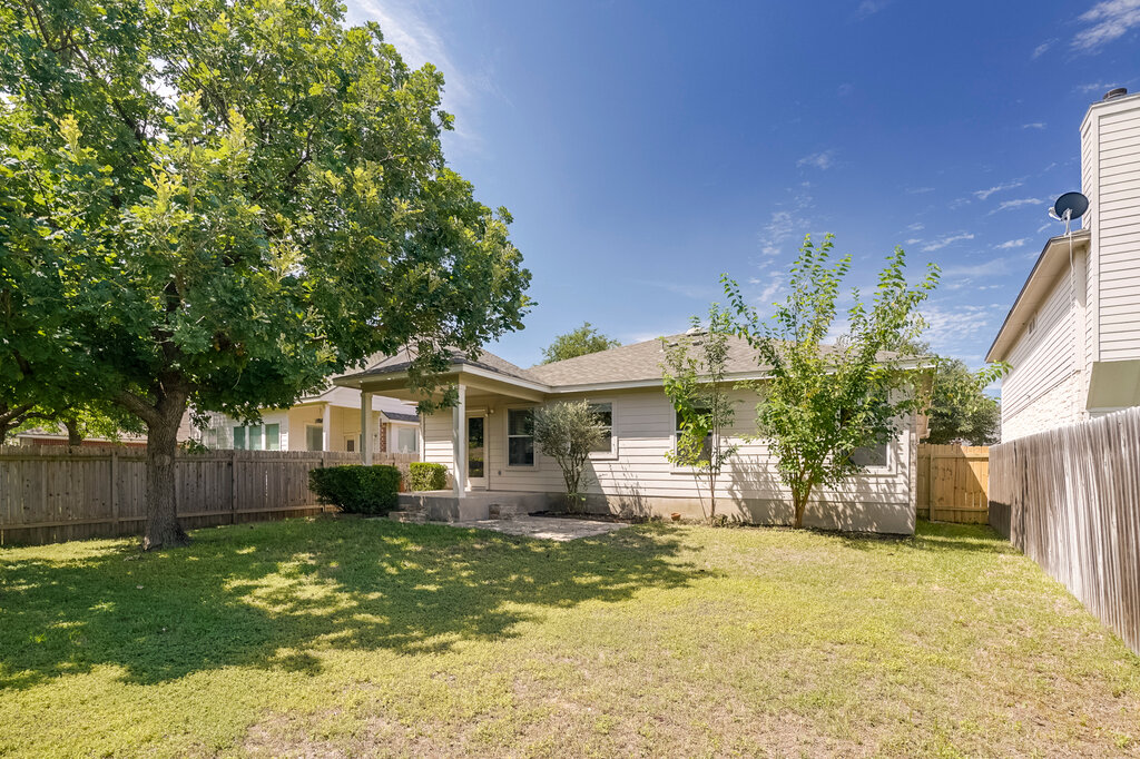 2724 Kickapoo Cavern Drive Pflugerville, TX 78660 - Photo 22 of 24 A verdant lawn and mature trees frame this charming residence, perfect for outdoor enjoyment.