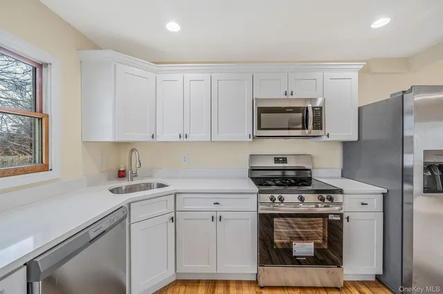a kitchen with cabinets stainless steel appliances a sink and a counter space