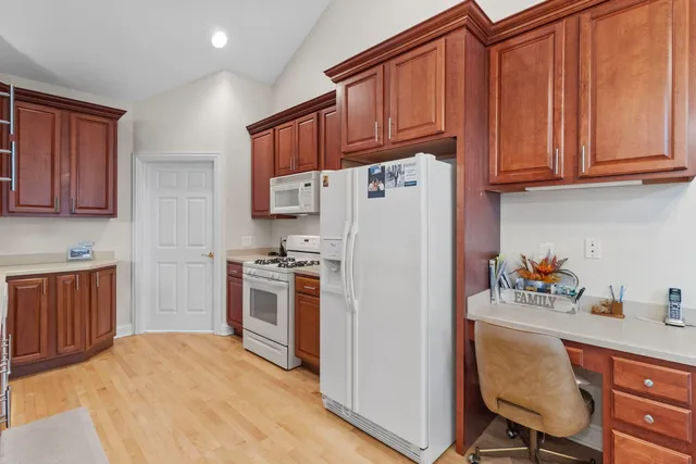 a kitchen with stainless steel appliances granite countertop a refrigerator and a stove top oven