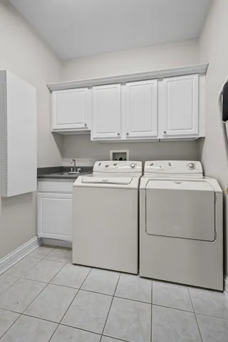 a utility room with dryer washer and a view of living room