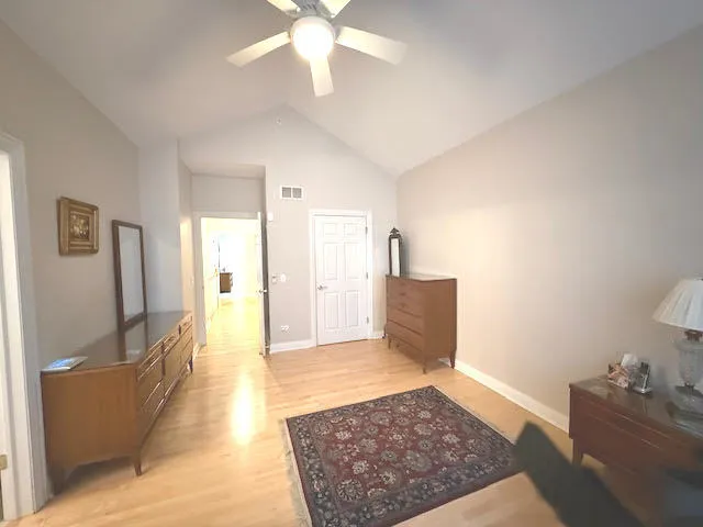 a view of a hallway with wooden floor and chandelier